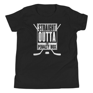 May include: Black youth t-shirt with a white graphic of hockey sticks and a box that says "Straight Outta The Penalty Box".