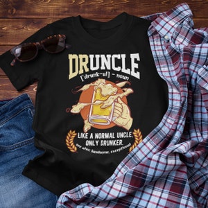 May include: Black t-shirt with a graphic of a beer mug and the text "DRUNCLE [drunk-ul] - noun LIKE A NORMAL UNCLE. ONLY DRUNKER. see also: handsome, exceptional"