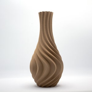 Puede incluir: Un jarrón de cerámica marrón con un diseño de remolino y textura. El jarrón tiene una base ancha y un cuello estrecho.