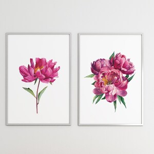 以下が含まれることがあります： ピンクの牡丹を描いた額装された水彩画2点。最初の絵は、緑色の茎と葉を持つ牡丹が1輪描かれている。2枚目の絵は、緑色の葉を持つ牡丹が3輪束ねられたブーケが描かれている。