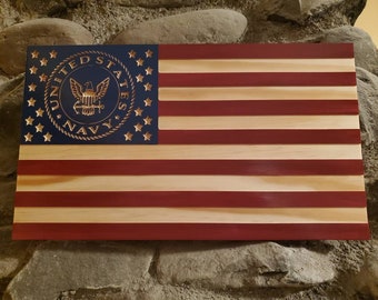 May include: A wooden American flag with a blue canton featuring a gold United States Navy seal. The flag has red and white stripes.