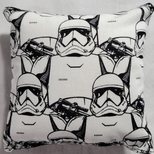 May include: White pillowcase with a black and white repeating pattern of Stormtrooper helmets from Star Wars.