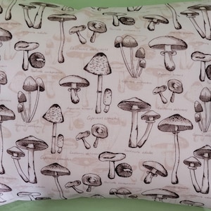 May include: A white pillowcase with a brown and white mushroom pattern. The mushrooms are drawn in a vintage style and have Latin names printed below them.