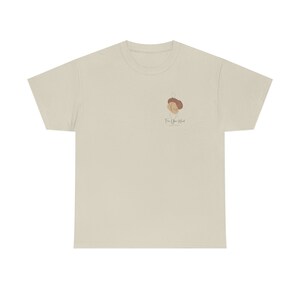 May include: A light beige t-shirt with a minimalist design on the upper left chest. The design features abstract shapes in brown and beige, with the text "For Your Mind" below. The shirt is made of a soft, comfortable material.