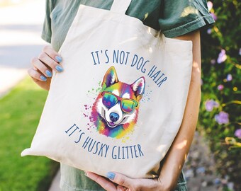 May include: A white tote bag with a colorful husky dog wearing sunglasses and the text "It's not dog hair, it's husky glitter".