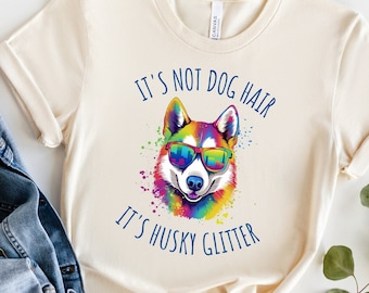 May include: A beige t-shirt with a colorful husky dog wearing sunglasses and the text "It's not dog hair, it's husky glitter".
