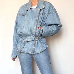 Puede incluir: Chaqueta vaquera azul claro con cintur&oacute;n y cierre de cremallera. La chaqueta tiene un cuello cl&aacute;sico, mangas largas y un corte relajado. Los vaqueros vaqueros a juego completan el conjunto. Una adici&oacute;n elegante y vers&aacute;til a cualquier armario.