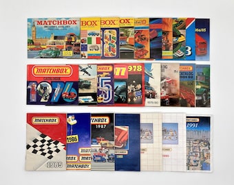 Könnte beinhalten: Eine Sammlung von Matchbox-Spielzeugautokatalogen von 1968 bis 1991. Die Kataloge zeigen farbenfrohe Bilder von Autos, Lastwagen und anderen Fahrzeugen. Die Kataloge sind chronologisch geordnet, wobei der älteste Katalog links und der neueste Katalog rechts ist.