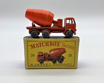 Könnte beinhalten: Ein roter Spielzeug-Betonmischer-LKW auf einem gelben Karton mit dem Text 'MATCHBOX' Series 26 A LESNEY PRODUCT'.