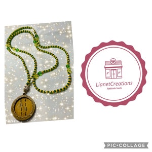 May include: A green and yellow beaded necklace with a wooden pendant featuring a road design. The pendant is round and has a brown finish. The necklace is handmade and is a unique piece of jewelry.