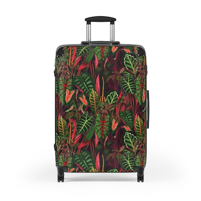 Two tropical-themed suitcases with a vibrant jungle-inspired design featuring green leaves, pink flowers, and colorful birds on a white background.