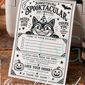 May include: A white thermal shipping label featuring a black ink illustration of a cat wearing a party hat, a crescent moon, a bat, and two jack-o'-lanterns. The text reads: SOMETHING SPOOKTACULAR HAS ARRIVED, PACKED WITH CARE, THANK YOU FOR SHOPPING SMALL.