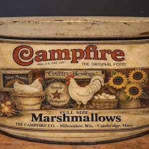 May include: Vintage Campfire Marshmallows tin with a rustic design. The label features illustrations of chickens, sunflowers, and the text "Campfire" and "Marshmallows". The tin is rectangular with a rounded top and has a distressed appearance.