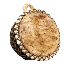 May include: A small, round drum with a light brown, textured drumhead. The drum's body is dark, with a woven pattern of dark brown string and white accents. A loop handle is attached at the top, made of the same light brown material.