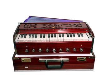 May include: A red harmonium with a keyboard, bellows, and a carrying case. The harmonium has a decorative floral design on the top and the text "AMRIT SINCE 1971".
