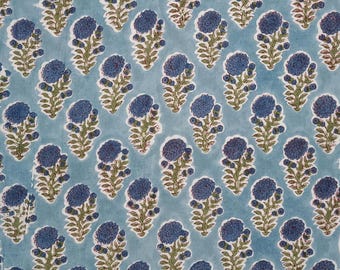 May include: A light blue fabric featuring a repeating pattern of dark blue floral motifs. Each motif consists of a single large, textured dark blue flower head atop a green stem with small green leaves, arranged in a consistent, evenly spaced grid.