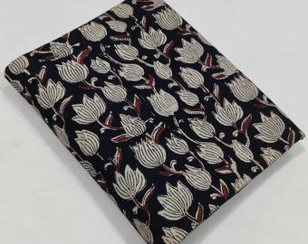 May include: Folded fabric with a repeating floral pattern. The design features cream-colored tulip-like flowers with maroon stems and leaves against a dark navy blue background. The fabric is folded neatly, suggesting it is ready for use.