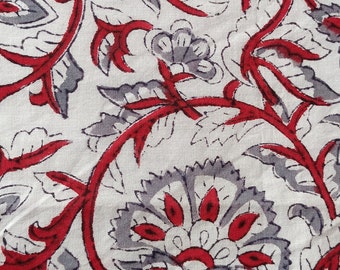 May include: Close-up of a white fabric with a repeating floral pattern. The design features gray and red flowers and vines. The flowers have red centers and gray petals, while the vines are red.