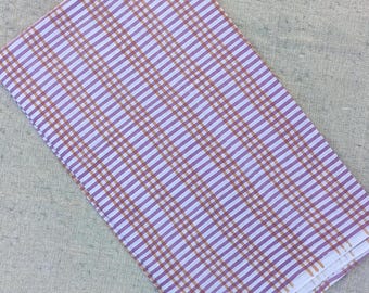 May include: Folded fabric with a plaid pattern in shades of lavender, white, and brown. The fabric is folded and appears to be made of a lightweight material. The plaid design is a classic pattern.
