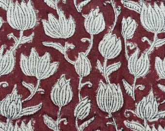 Könnte beinhalten: Nahaufnahme eines Stoffes mit einem sich wiederholenden Blumenmuster. Weiße, stilisierte Blumen und Blätter sind auf einem tiefroten Hintergrund gedruckt. Das Design hat ein strukturiertes Aussehen, was auf ein gewebtes Material hindeutet.
