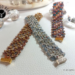 May include: Three beaded bracelets with gold and silver clasps. The bracelets are made with different colored beads in a checkered pattern. The bracelets are on a white surface. "Dare to Bead - heather faithwaite - designs" is written on a tag in the background.