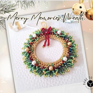 Puede incluir: Una corona navideña hecha a mano con cuentas con el texto "Merry Memories Wreath". La corona presenta cuentas verdes, doradas y rojas, con un lazo rojo y acentos de perlas blancas. Dos campanas doradas cuelgan en el fondo.