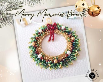 以下が含まれることがあります： 「Merry Memories Wreath」の文字が入った、手作りのビーズクリスマスリース。緑、金、赤のビーズ、赤いリボン、白いパールのアクセントが特徴です。背景には2つの金のベルが吊り下げられています。