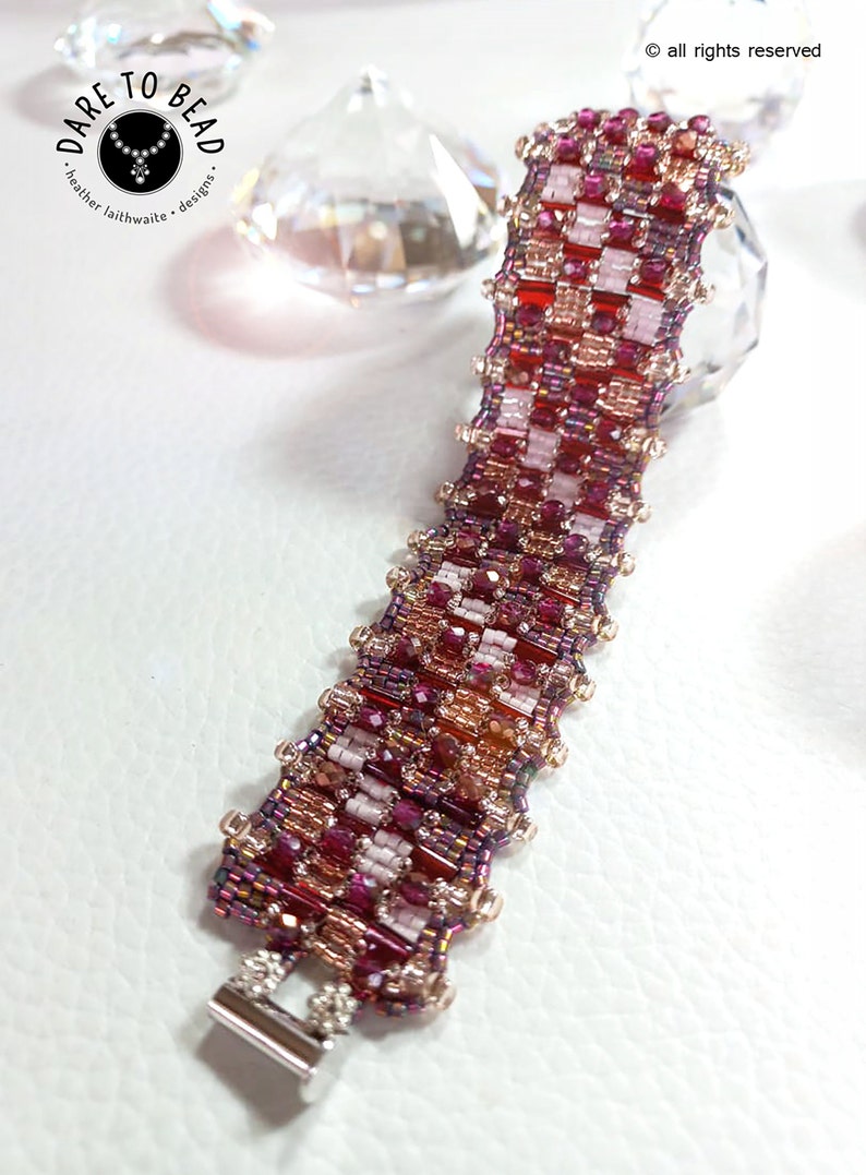 May include: A beaded bracelet with a silver clasp. The bracelet is made with red, pink, and gold beads in a geometric pattern.