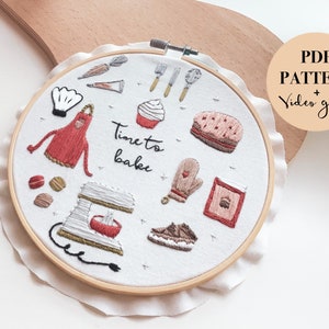 Può includere: Arte ricamata su un cerchio con sfondo bianco e varie illustrazioni a tema pasticceria, tra cui un grembiule rosso, una planetaria, un cupcake e una torta. Il testo "Time to bake" è ricamato al centro del cerchio.
