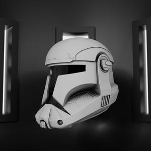 May include: A gray, futuristic helmet with a visor and detailed design. The helmet has a prominent chin and ear pieces, and is likely part of a costume or cosplay item. The background is dark with vertical light panels.