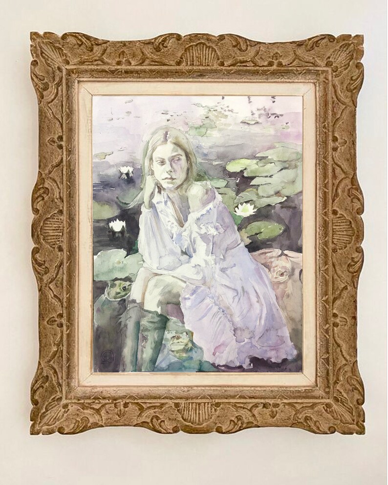 May include: Watercolor painting in a decorative gold frame. The artwork depicts a woman in a white dress seated among lily pads. The frame has ornate detailing. The painting has a soft, ethereal quality with muted colors.