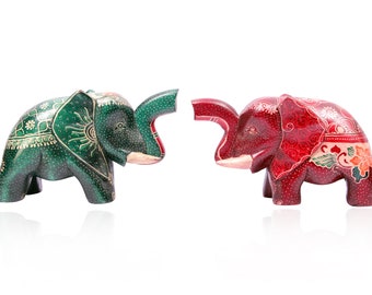 May include: Two hand-painted wooden elephant figurines facing each other. The elephant on the left is green with gold accents and the elephant on the right is red with gold accents.