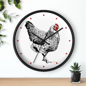 May include: A round wall clock with a black frame and a white face featuring a detailed black and white illustration of a chicken with a red comb and wattle. The clock has black hands and small red dots marking the hours around the perimeter.