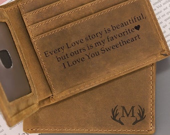 May include: A brown leather wallet with a card slot, a window for an ID, and a personalized message that reads "Every Love story is beautiful, but ours is my favorite. I Love You Sweetheart." The wallet also has a monogram with the letter "M" and antlers.