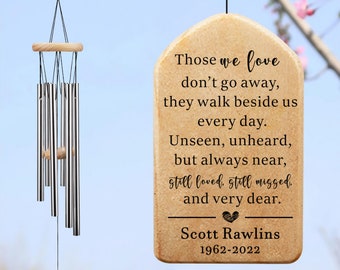 May include: A beige wooden wind chime with a heart and the text "Those we love don't go away, they walk beside us every day. Unseen, unheard, but always near, still loved, still missed, and very dear. Scott Rawlins 1962-2022"