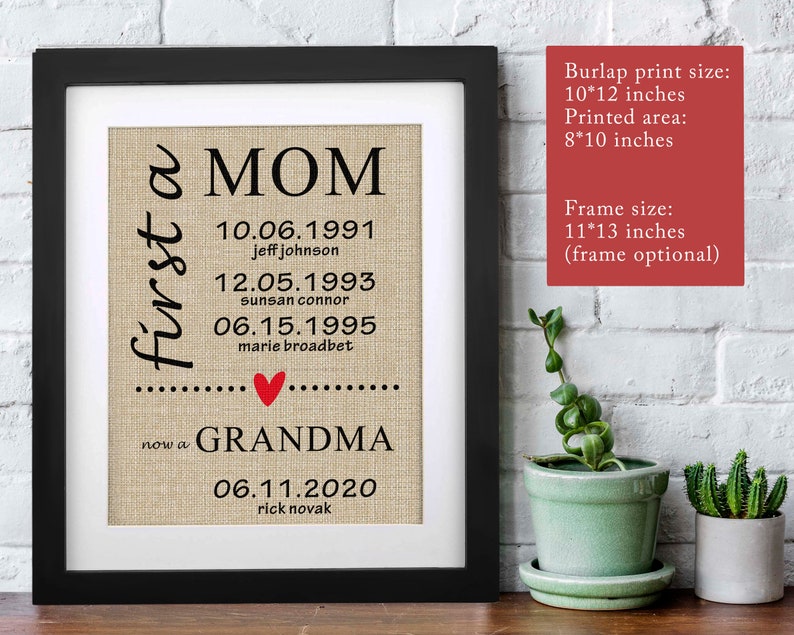 May include: Framed burlap print with black text that reads "first a MOM" and "now a GRANDMA." Dates and names are listed below. A red heart is between the two phrases. The frame is black. The burlap print size is 10x12 inches.