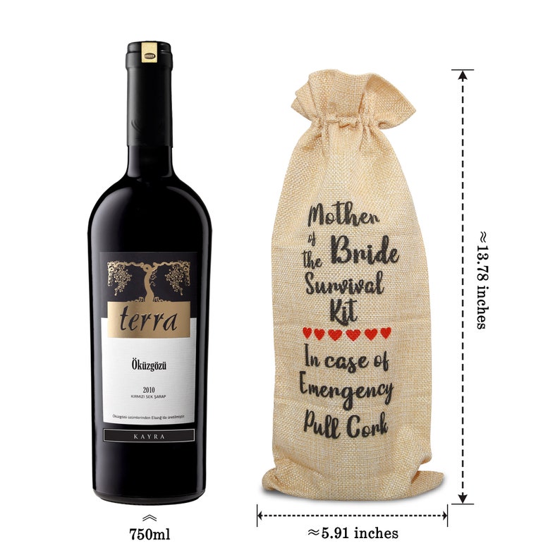 May include: A bottle of red wine next to a burlap wine bag. The wine bottle has a black label with gold lettering and the text "terra" and "&Ouml;k&uuml;zg&ouml;z&uuml;". The bag reads "Mother of the Bride Survival Kit" and is approximately 13.78 inches tall.