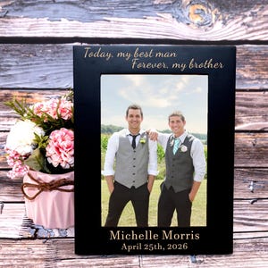 May include: Black picture frame with the text "Today, my best man Forever, my brother" in gold lettering. The frame holds a photo of two men in vests and dress shirts. The bottom of the frame reads "Michelle Morris April 25th, 2026".