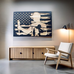 May include: Wooden wall art depicting a silhouette of a person holding a tool, set against a backdrop of the American flag. The artwork is made of light-colored wood and black paint. The piece is mounted above a wooden cabinet.