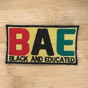May include: A yellow, black, red, and green embroidered patch with the letters "BAE" in large font and the words "Black and Educated" in smaller font below.
