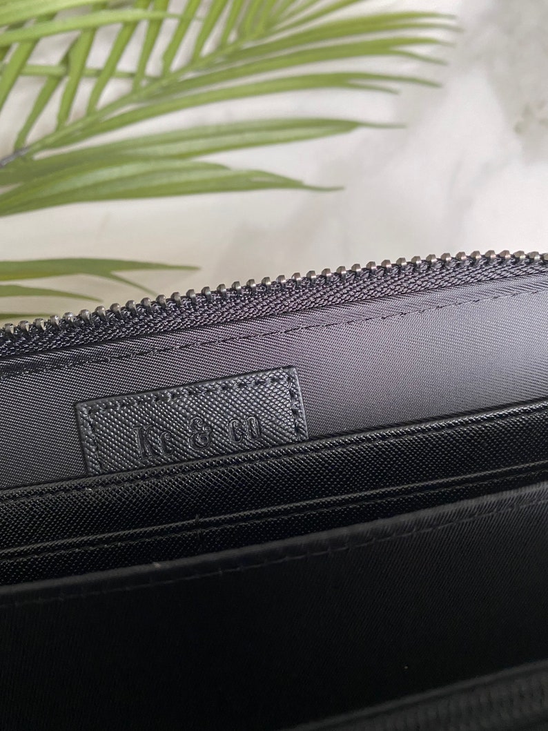 May include: Black zippered wallet with a black fabric lining and the text "L.L. Bean" printed on the inside.