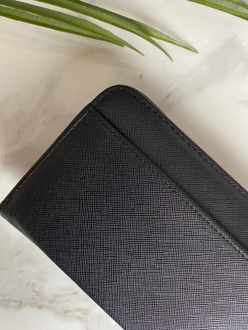 May include: Black leather wallet with a textured finish.