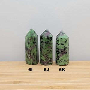 May include: Three green, black, and pink zoisite crystal points, labeled 6I, 6J, and 6K.