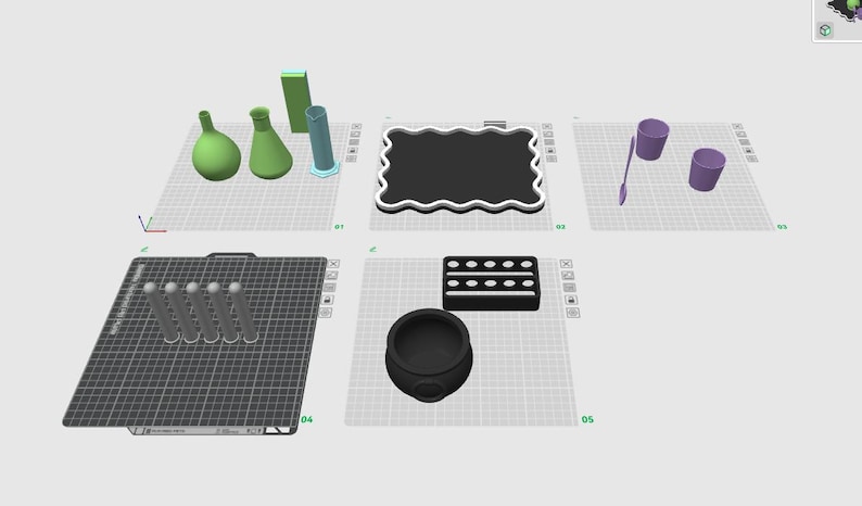 May include: A digital 3D modeling interface displaying various objects on five separate grid platforms, including green laboratory glassware, a black scalloped tray, purple cups, a spoon, five gray cylinders, a black rectangular tray, and a cauldron.