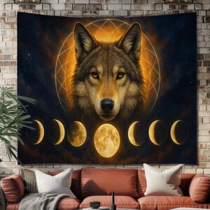 Peut inclure: Une tapisserie représentant un visage de loup au centre d'un motif de capteur de rêves doré. En dessous, une série de phases lunaires illuminées sont affichées. L'œuvre est placée sur un fond sombre et étoilé.
