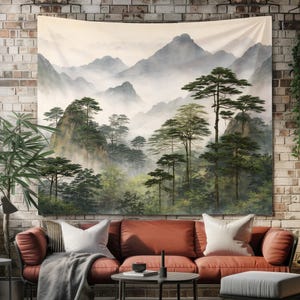May include: A large tapestry depicting a misty mountain landscape with evergreen trees. The artwork features a muted color palette of greens, grays, and beige. The tapestry is hanging above a rust-colored sofa with white pillows, creating a serene atmosphere.