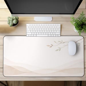 May include: A rectangular beige mouse pad with a black border. The design features a watercolor-style branch with leaves and a subtle wave pattern in shades of beige. A white mouse and keyboard are on the pad.