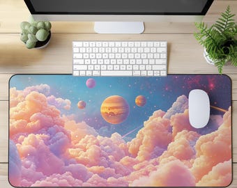 Puede incluir: Alfombrilla de escritorio rectangular con un diseño espacial de ensueño, que muestra planetas y nubes de colores pastel. El diseño incluye un cielo azul con estrellas y planetas en tonos naranja, rosa y morado. Un ratón y un teclado blancos están sobre el escritorio.
