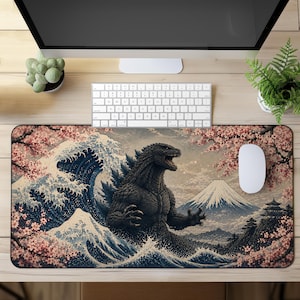 May include: A rectangular desk mat featuring a detailed illustration of a dark, textured monster standing amidst a large, stylized blue ocean wave. The scene includes a snow-capped mountain in the background, a pagoda, and pink cherry blossom branches.