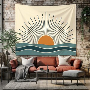 Pu&ograve; includere: Un arazzo beige con un design minimalista raffigurante un sole arancione, con linee blu scuro, sopra onde turchesi. L'arazzo &egrave; appeso a un muro di mattoni, sopra un divano rosso, creando un'atmosfera calda e invitante.